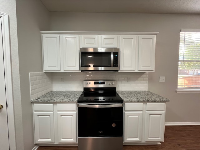 kitchen with tasteful backsplash, white cabinets, and stainless steel appliances