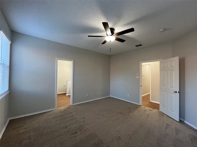 unfurnished bedroom with carpet, ceiling fan, and a textured ceiling