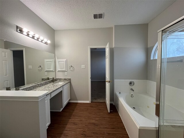 bathroom featuring vanity, wood-type flooring, a textured ceiling, and toilet