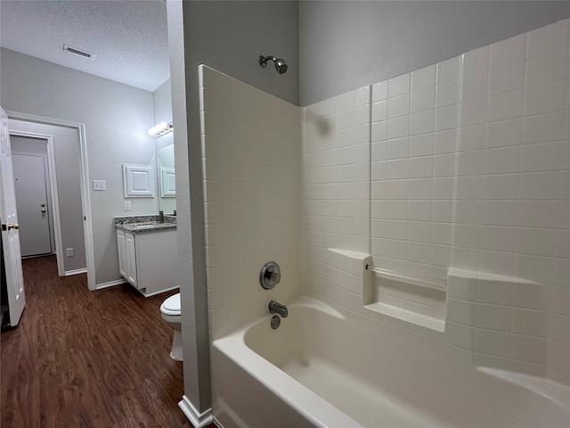 full bathroom with vanity, wood-type flooring, toilet, a textured ceiling, and shower / bath combination