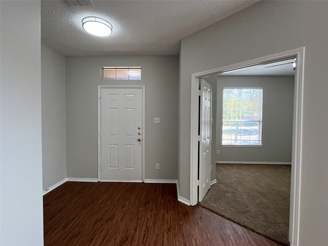 entrance foyer with dark hardwood / wood-style flooring and a textured ceiling