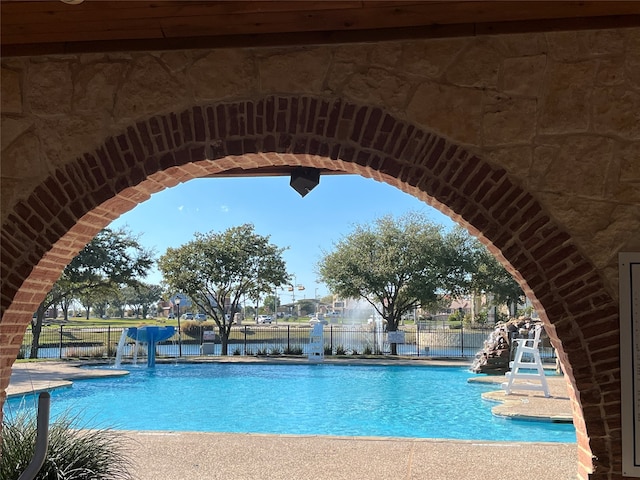 view of swimming pool with pool water feature