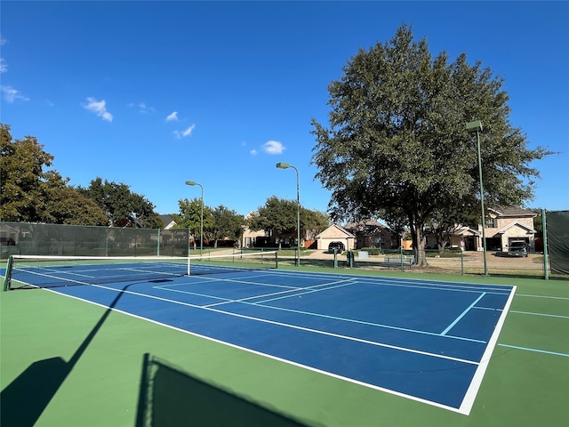 view of tennis court featuring basketball hoop