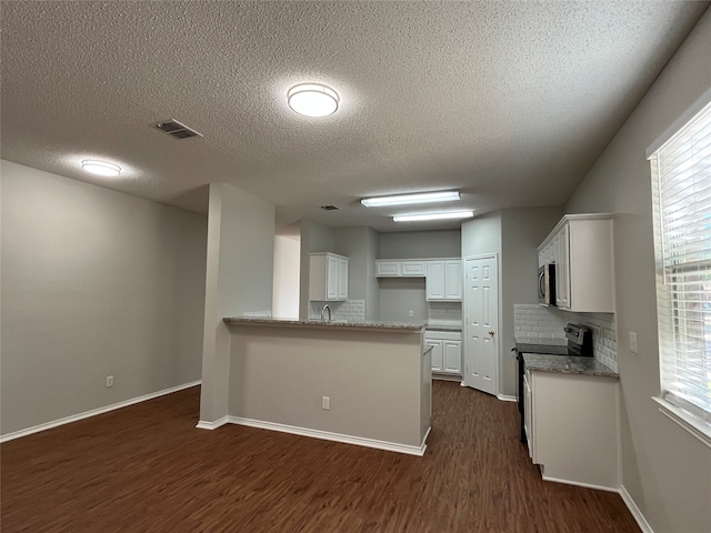 kitchen featuring dark hardwood / wood-style floors, decorative backsplash, white cabinetry, kitchen peninsula, and stainless steel appliances