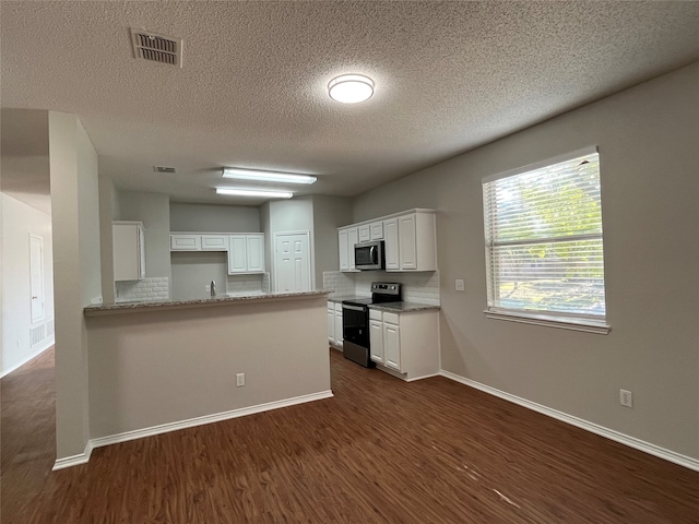 kitchen with kitchen peninsula, appliances with stainless steel finishes, dark hardwood / wood-style flooring, backsplash, and white cabinets