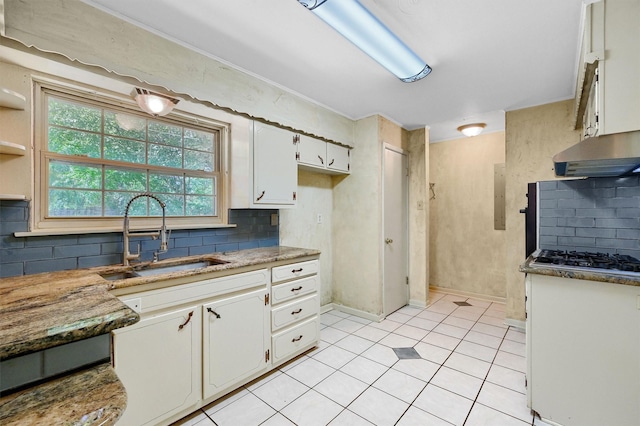 kitchen with stainless steel gas stovetop, backsplash, electric panel, white cabinets, and sink