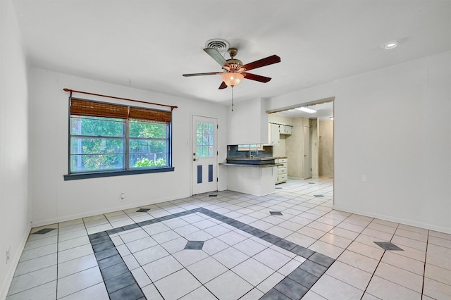 unfurnished living room featuring ceiling fan and light tile patterned floors