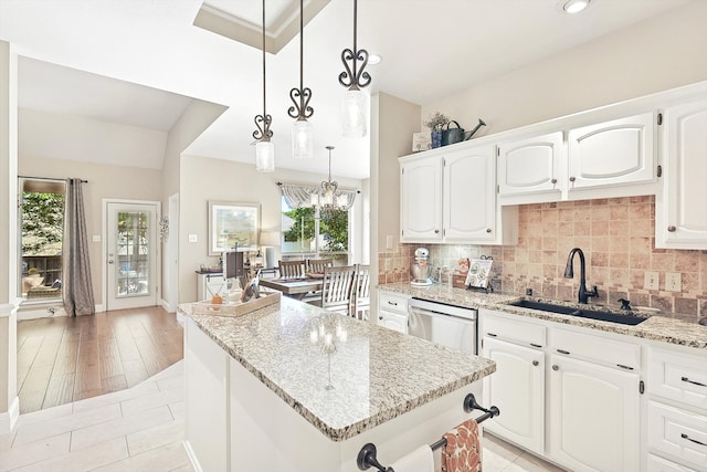 kitchen featuring pendant lighting, sink, light hardwood / wood-style flooring, a kitchen island, and white cabinetry