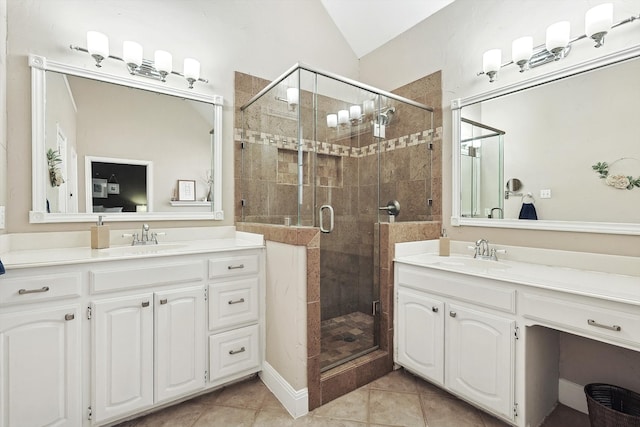 bathroom featuring tile patterned flooring, vanity, vaulted ceiling, and a shower with door