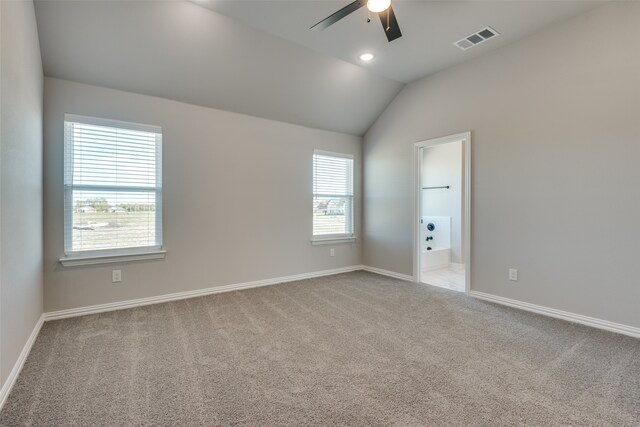 spare room with ceiling fan, plenty of natural light, light colored carpet, and lofted ceiling