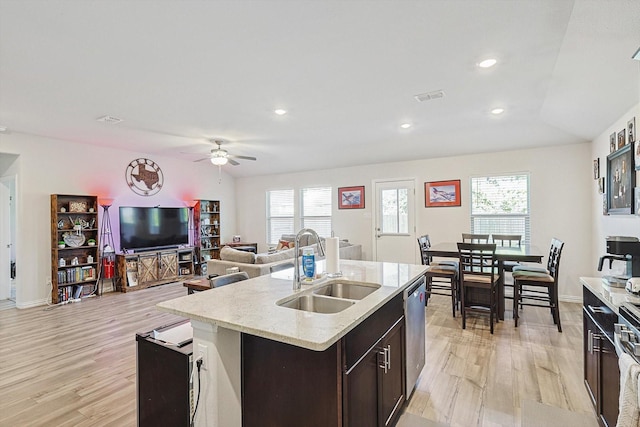 kitchen featuring sink, dishwasher, ceiling fan, a wealth of natural light, and a kitchen island with sink