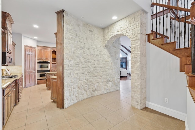 kitchen featuring decorative backsplash, light tile patterned floors, and appliances with stainless steel finishes