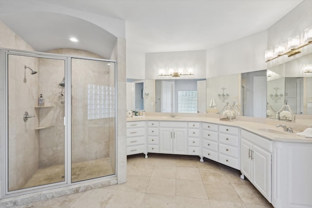 bathroom featuring tile patterned floors, a shower with door, and vanity