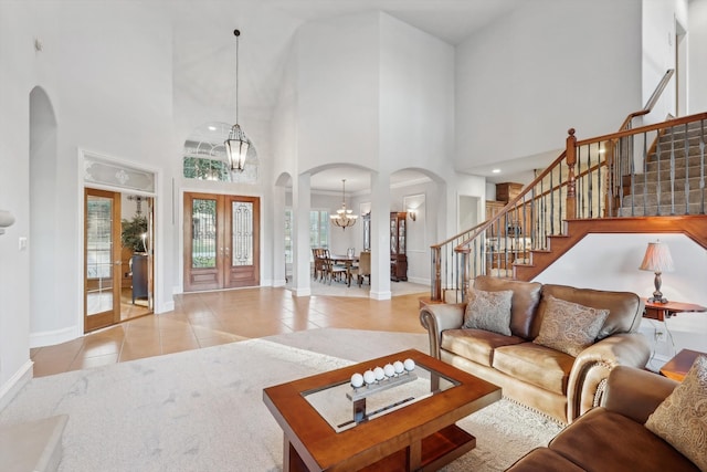 living room with plenty of natural light, french doors, a chandelier, and a high ceiling