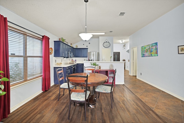 dining room featuring a textured ceiling, dark hardwood / wood-style flooring, and vaulted ceiling