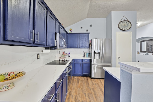 kitchen with lofted ceiling, dark hardwood / wood-style floors, light stone countertops, blue cabinetry, and stainless steel appliances