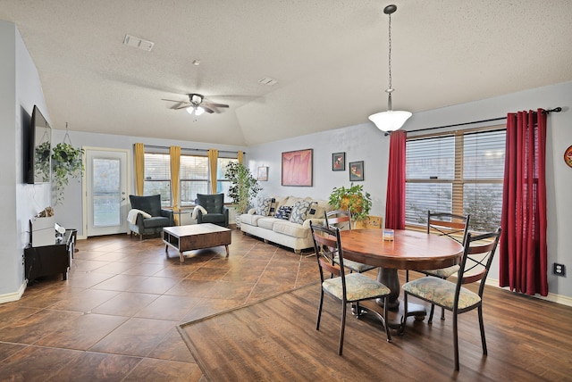 dining area with a textured ceiling, ceiling fan, and lofted ceiling