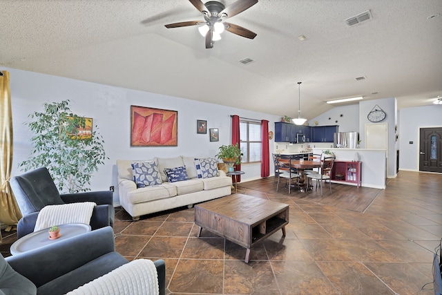 living room with ceiling fan, a textured ceiling, and vaulted ceiling