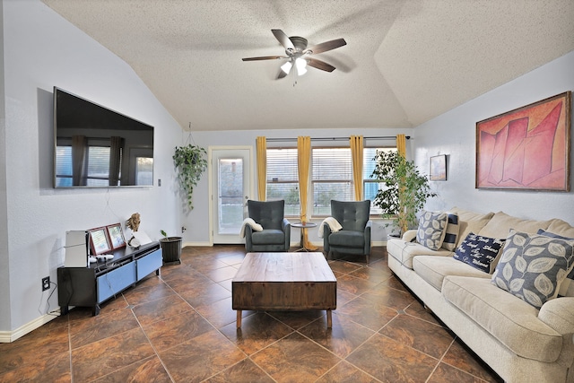 living room featuring vaulted ceiling, ceiling fan, and a textured ceiling