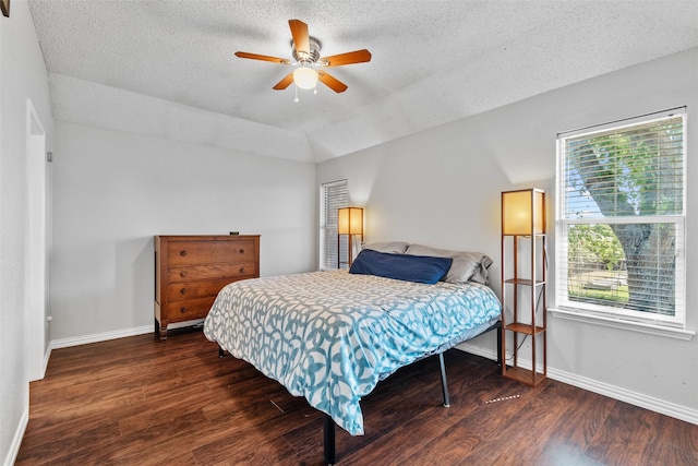 bedroom with a textured ceiling, ceiling fan, vaulted ceiling, and dark hardwood / wood-style floors