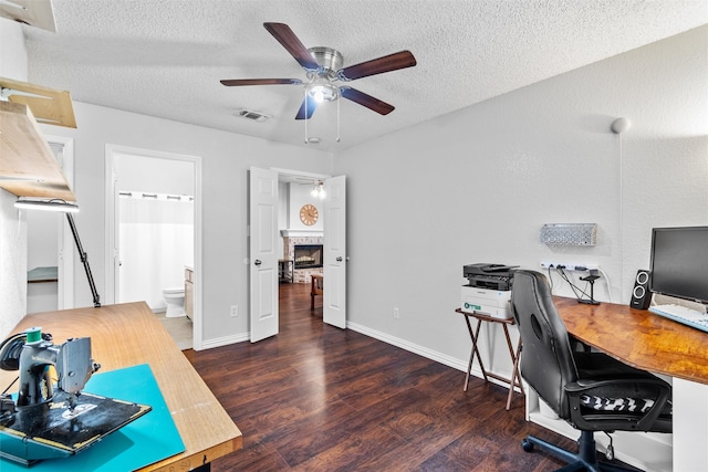 office space with a textured ceiling, ceiling fan, and dark wood-type flooring