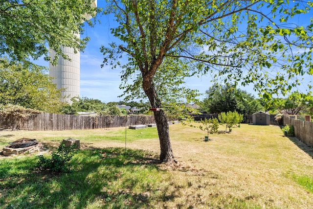 view of yard featuring a fire pit and a storage shed