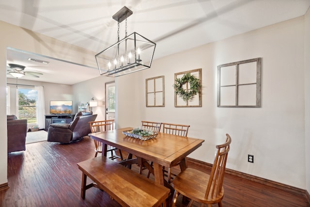 dining room featuring ceiling fan with notable chandelier and dark hardwood / wood-style flooring