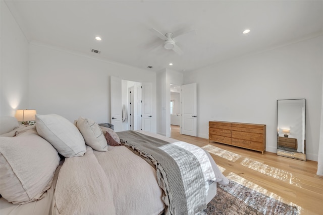 bedroom with wood-type flooring, ceiling fan, and ornamental molding