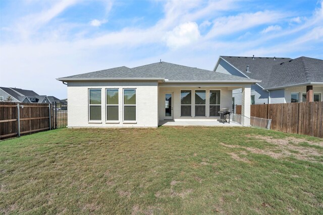 back of house featuring a patio area and a yard