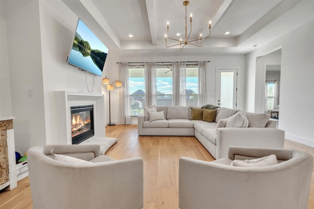 living room with a chandelier, beam ceiling, and light hardwood / wood-style flooring