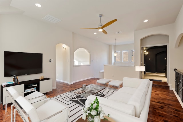 living room with ceiling fan and dark wood-type flooring