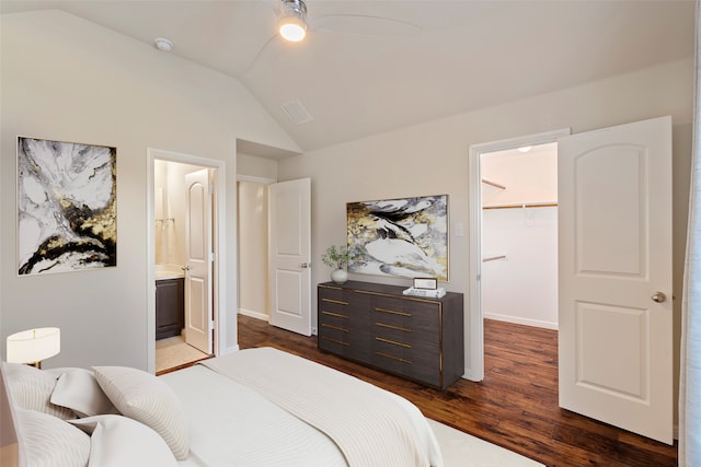 bedroom with connected bathroom, a spacious closet, dark hardwood / wood-style flooring, lofted ceiling, and a closet