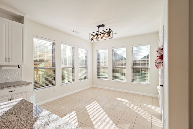 unfurnished dining area with a healthy amount of sunlight and light tile patterned flooring