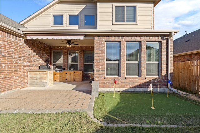 exterior space featuring an outdoor kitchen, ceiling fan, and a patio area