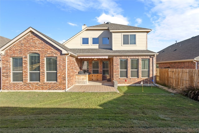 back of house featuring area for grilling, a patio area, and a yard