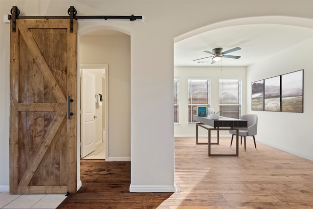 corridor featuring a barn door and hardwood / wood-style floors