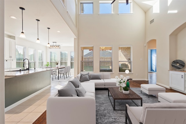 tiled living room with a towering ceiling and sink