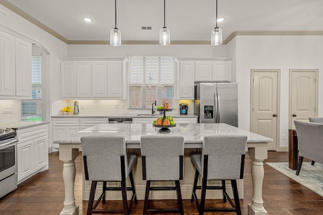 kitchen featuring a center island, stainless steel appliances, hanging light fixtures, and dark hardwood / wood-style floors