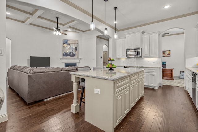 kitchen with white cabinetry, a center island, a kitchen breakfast bar, tasteful backsplash, and dark hardwood / wood-style flooring