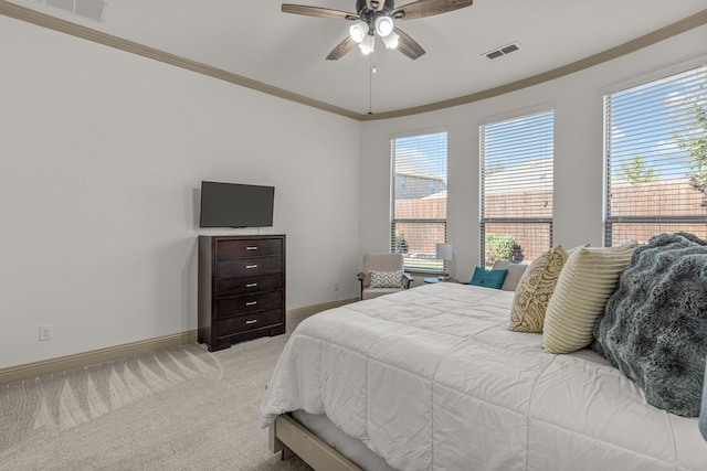 carpeted bedroom with multiple windows, ceiling fan, and ornamental molding