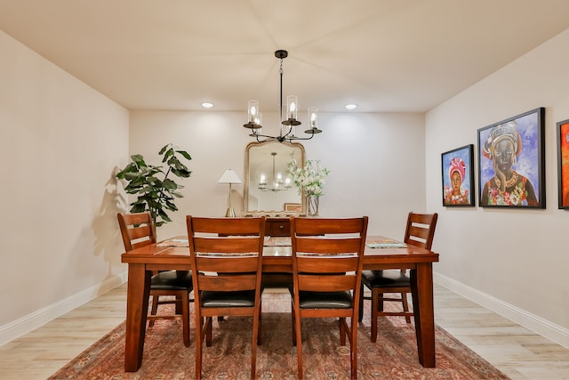 dining room with hardwood / wood-style flooring and a notable chandelier