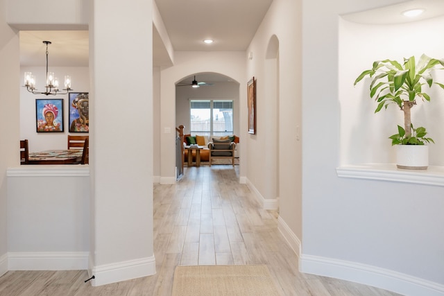 hall featuring a notable chandelier and light hardwood / wood-style floors