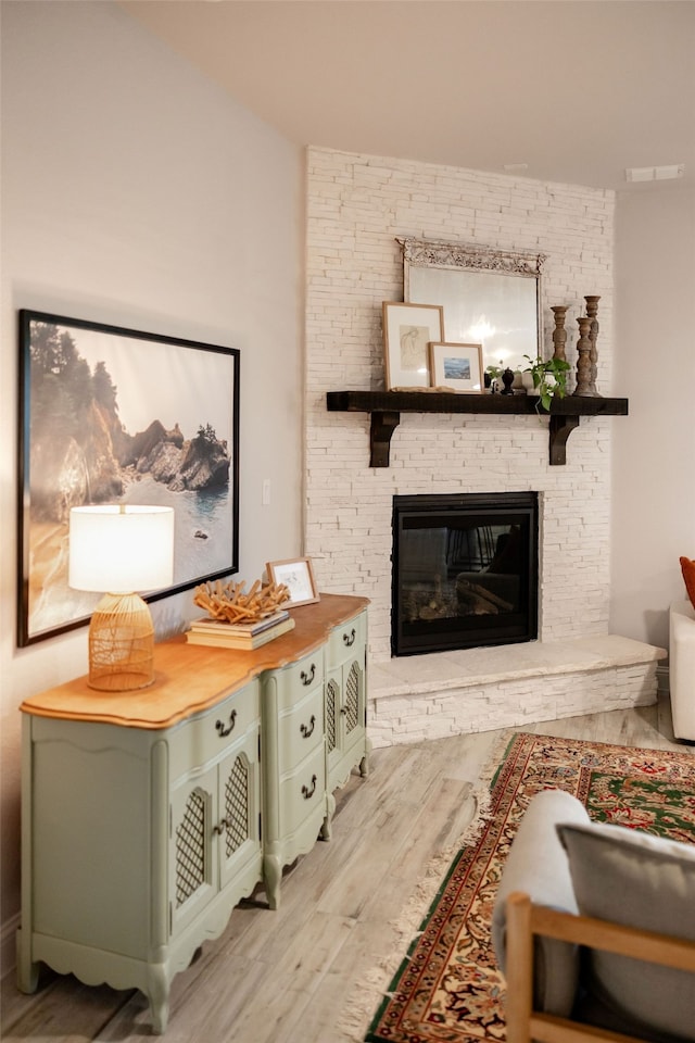 interior space with light hardwood / wood-style floors and a stone fireplace