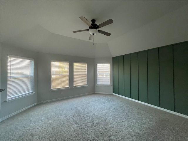 carpeted empty room with ceiling fan and vaulted ceiling