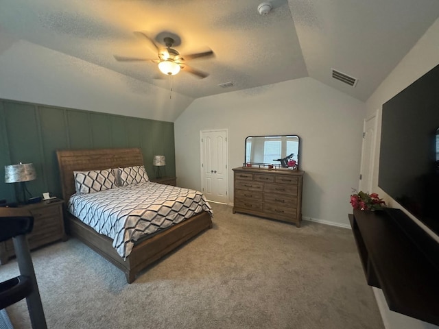 bedroom with carpet flooring, a textured ceiling, ceiling fan, a closet, and lofted ceiling