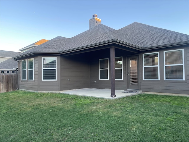 back of house with a lawn and a patio