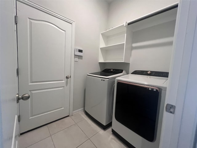 clothes washing area with independent washer and dryer and light tile patterned floors