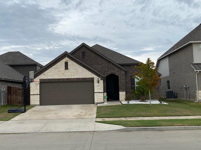 view of front facade with a front yard, a garage, and central air condition unit