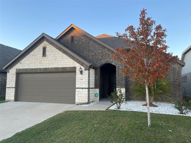 view of front of home with a front yard and a garage