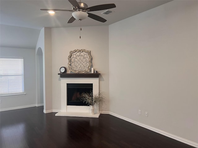 unfurnished living room featuring ceiling fan and dark hardwood / wood-style flooring